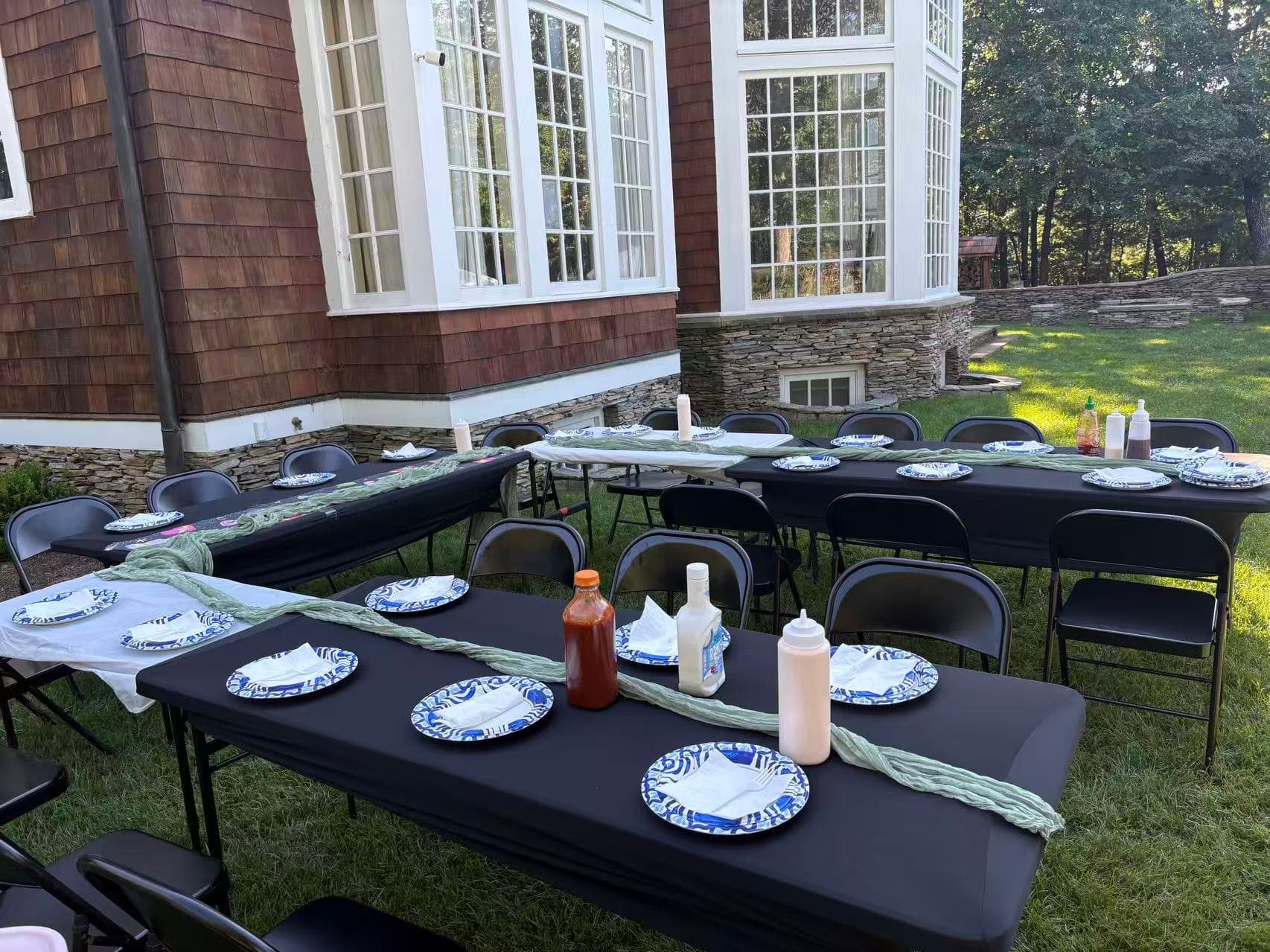 Outdoor tables and chairs arranged around a hibachi grill for a private dinner